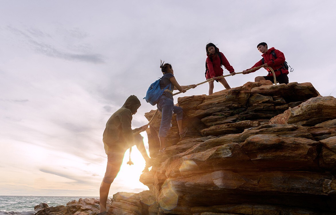 A group of friends climbing a rock